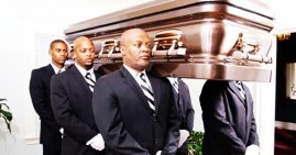 African American men carrying casket at funeral