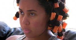 Black woman wearing hair rollers