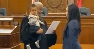 Judge holding baby while swearing in lawyer