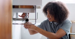 Woman fixing plumbing