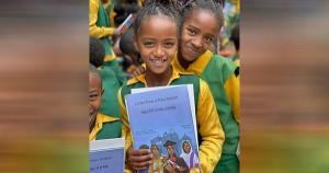 African children holding Letters From a Plow Nation book