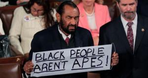 Al Green holding Black People Aren't Apes signage
